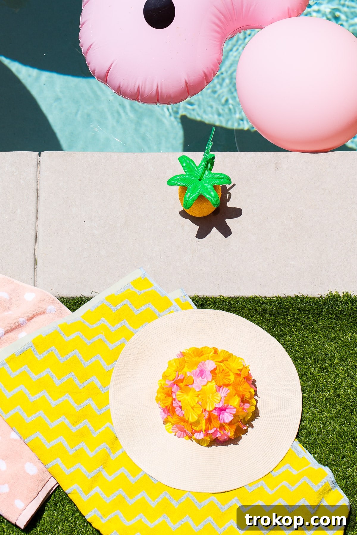 A beautifully decorated DIY floral floppy hat, ready for a stylish day by the pool.