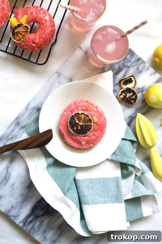 Close-up of pink lemonade donut with sprinkles and lemon zest