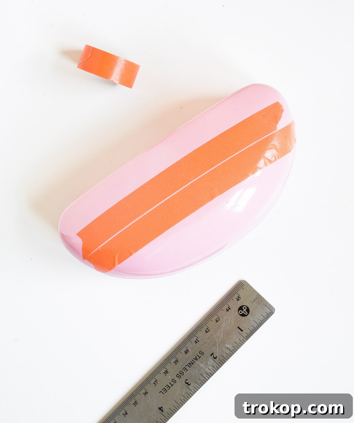 Close-up of vinyl letters being spray-painted on a protective surface for the DIY sunglasses case.
