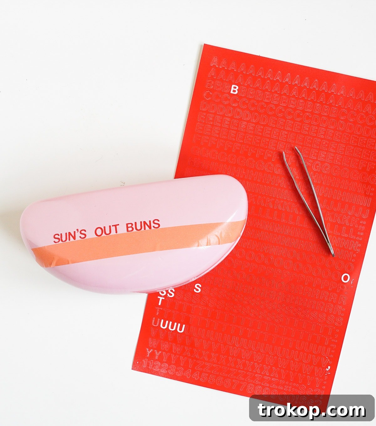 Applying vinyl letters to a sunglasses case using washi tape as a guide.