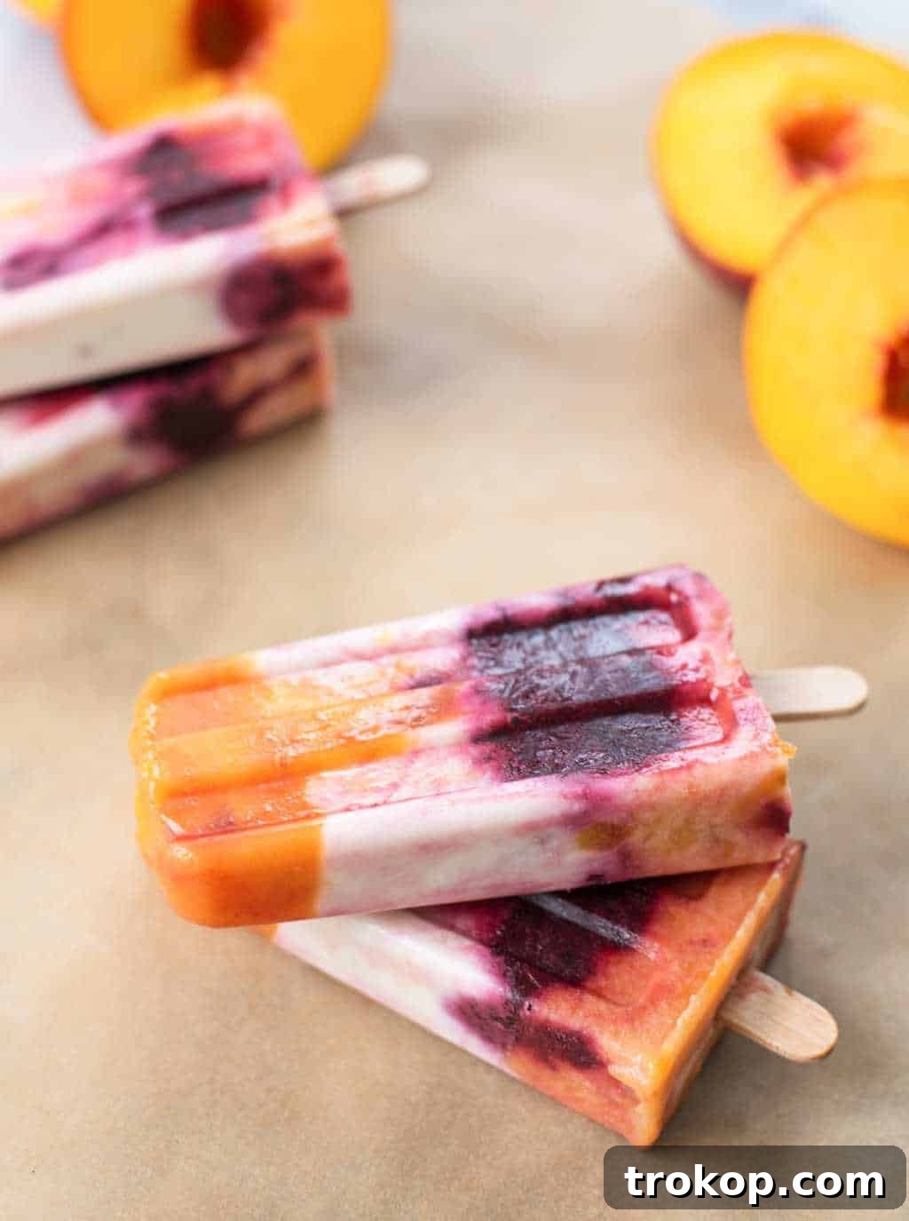 Delicious Roasted Peach and Cherry Popsicles layered with vibrant fruit and creamy coconut milk, a refreshing summer treat