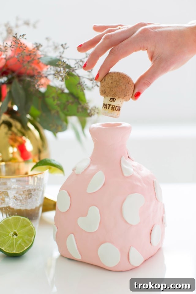 A stylish, finished DIY clay decanter with a unique texture, positioned beautifully on a bar cart alongside other decorative elements.