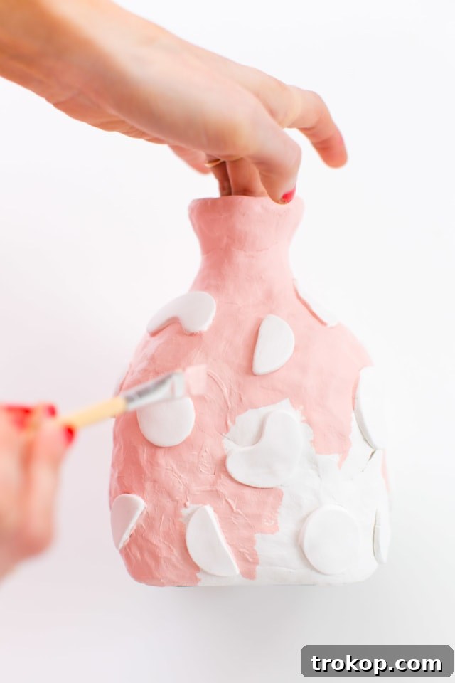 A beautifully painted DIY clay decanter, showcasing intricate details and vibrant colors, ready for sealing and use.