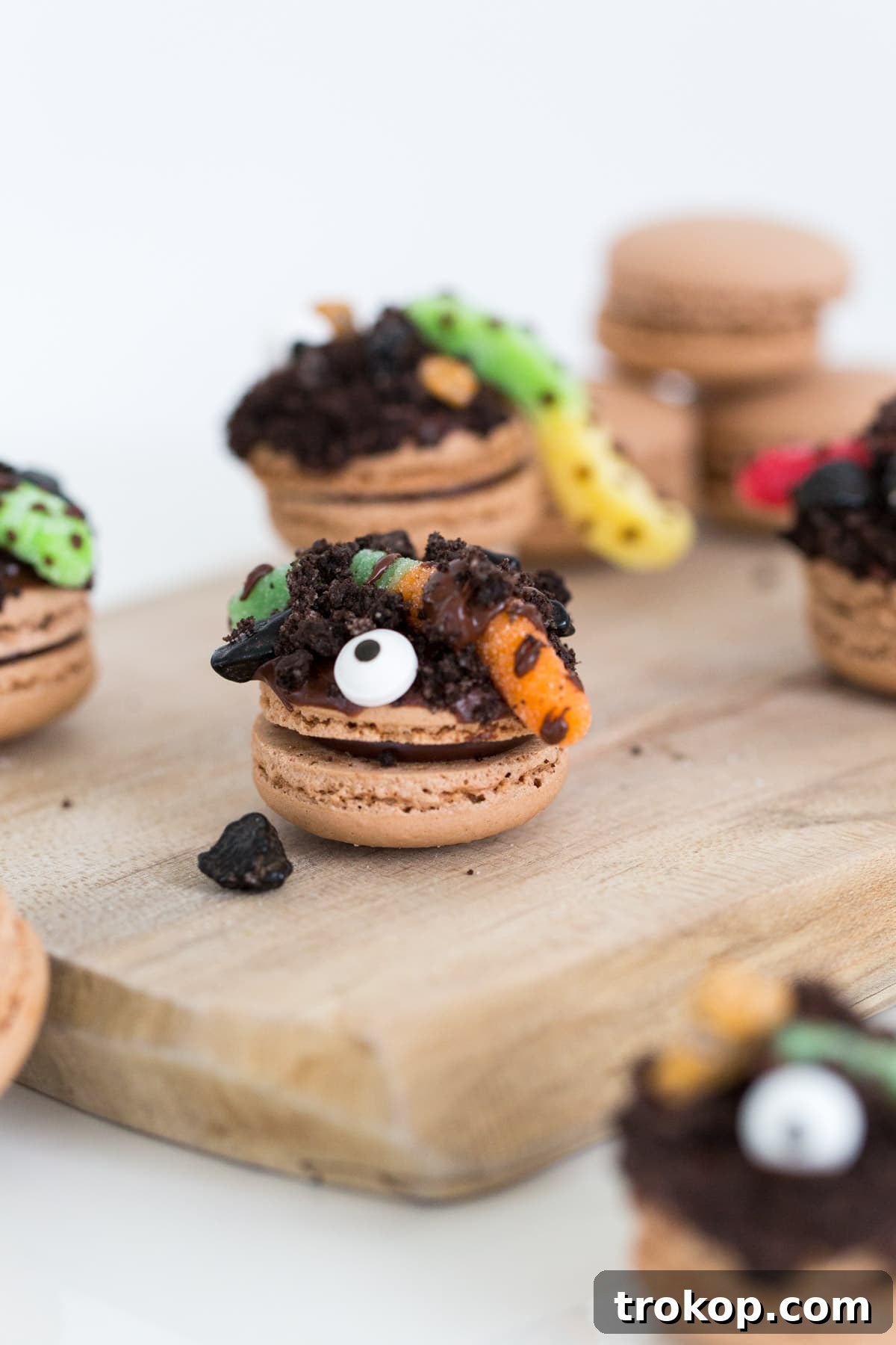 The cutest DIY dirt worm macarons for Halloween with chocolate and gummy worms.