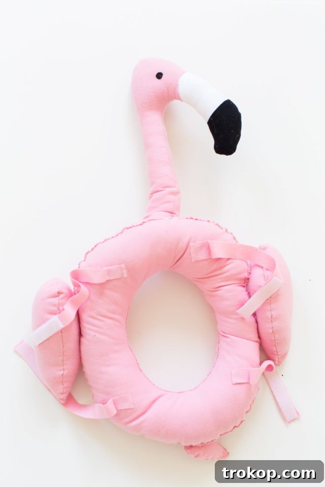 Dog wearing a DIY flamingo pool float costume, close-up on the head