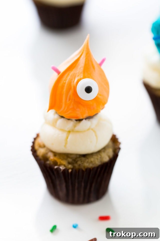 Adorable Truffle Monster Cake Toppers Recipe 3 Close-up of a finished DIY Truffle Monster Cupcake Topper with vibrant marbled icing and edible eyes