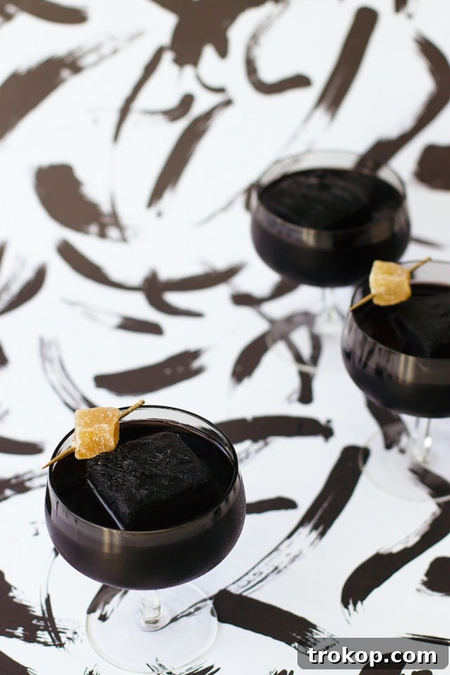 Activated Charcoal Elixirs: Detox Cocktails and Mocktails 4 A vibrant and inviting activated charcoal cocktail with a lime garnish, celebrating a joyful 'Happy Friyay!'