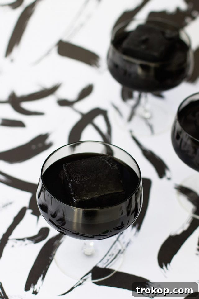 Activated Charcoal Elixirs: Detox Cocktails and Mocktails 5 Close-up of activated charcoal powder being added to a cocktail shaker, illustrating the first step in making the detox drink.