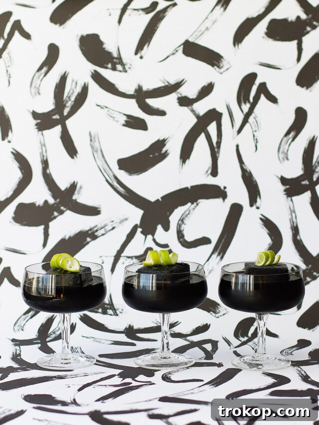 Activated Charcoal Elixirs: Detox Cocktails and Mocktails 9 Close-up of a refreshing Detox Activated Charcoal Cocktail, showcasing its unique dark color and elegant presentation in a coupe glass.