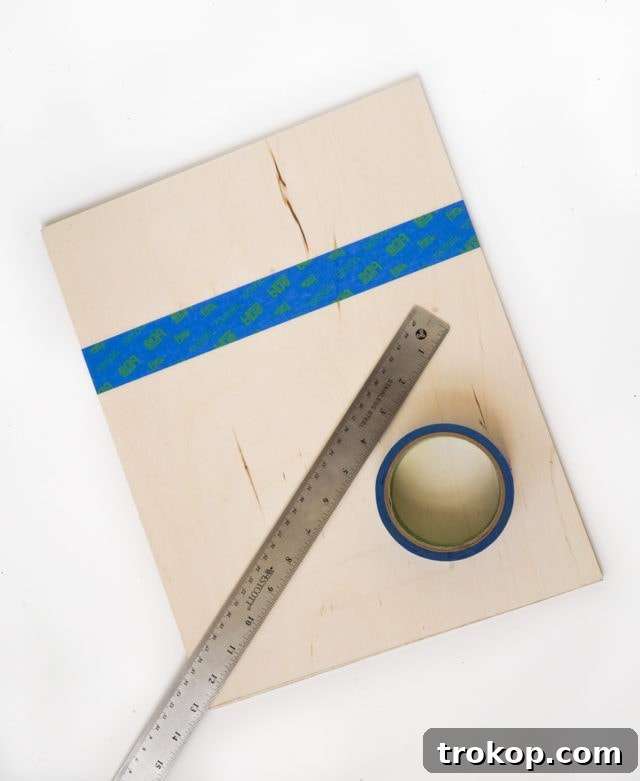 Craft Your Own Clip Memo Board 5 Applying Painter's Tape to the Plywood Board for a Clean Paint Line