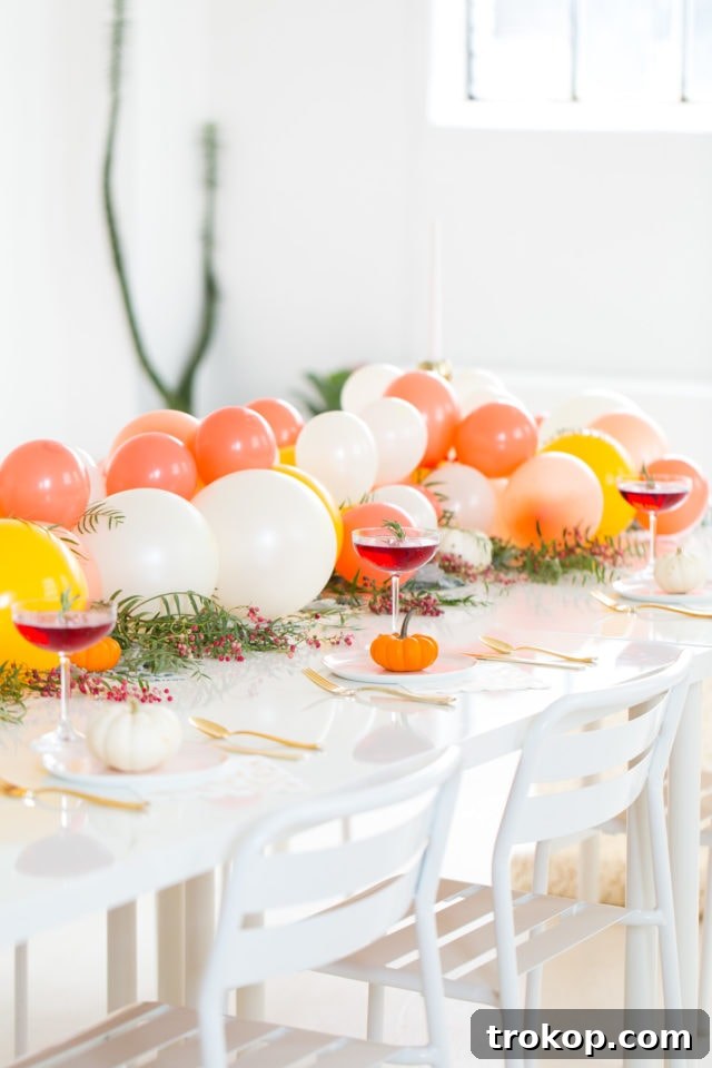 Close-up of a delicious Blackberry Blitz cocktail garnished with rosemary, alongside a balloon centerpiece