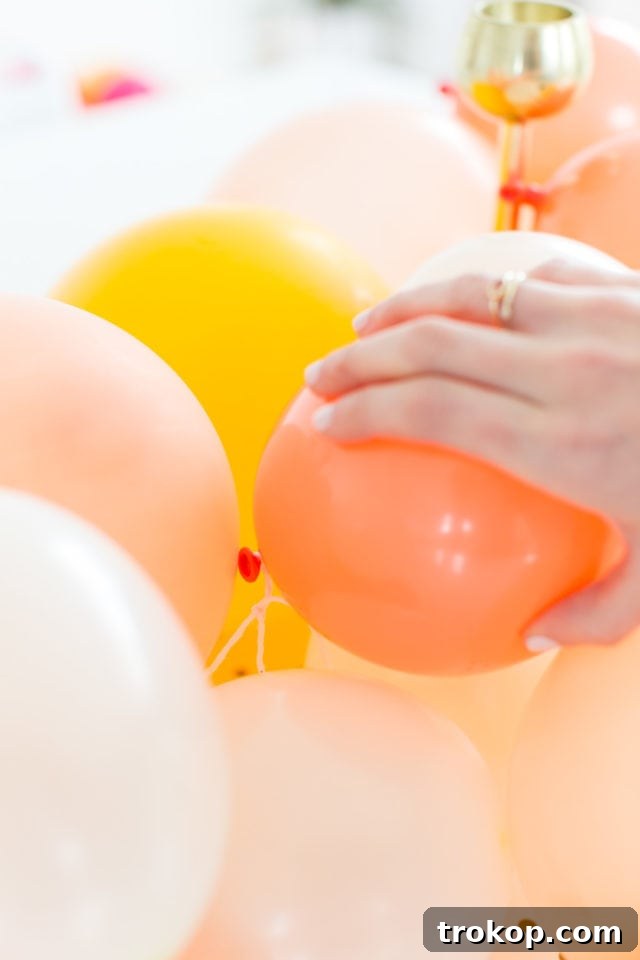 Arranging pastel latex balloons on a string for a DIY centerpiece