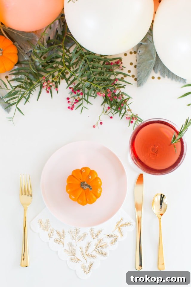 Elegant Friendsgiving table with a balloon centerpiece, drinks, and decor elements