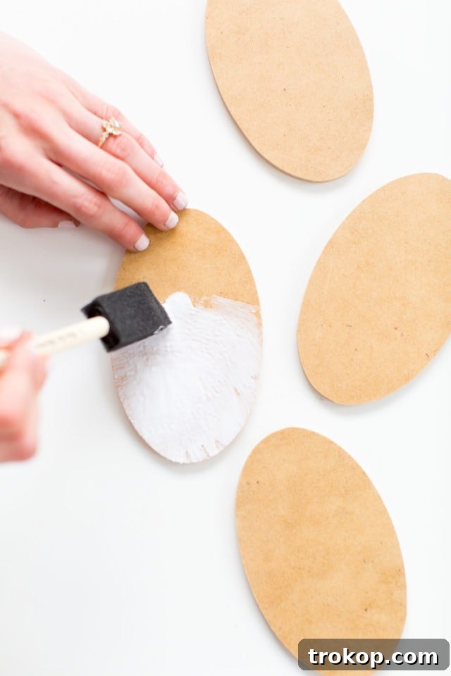 Kick Off Your Table with DIY Football Coasters and Mats 5 Applying craft glue to an oval wood cutout for DIY football coasters