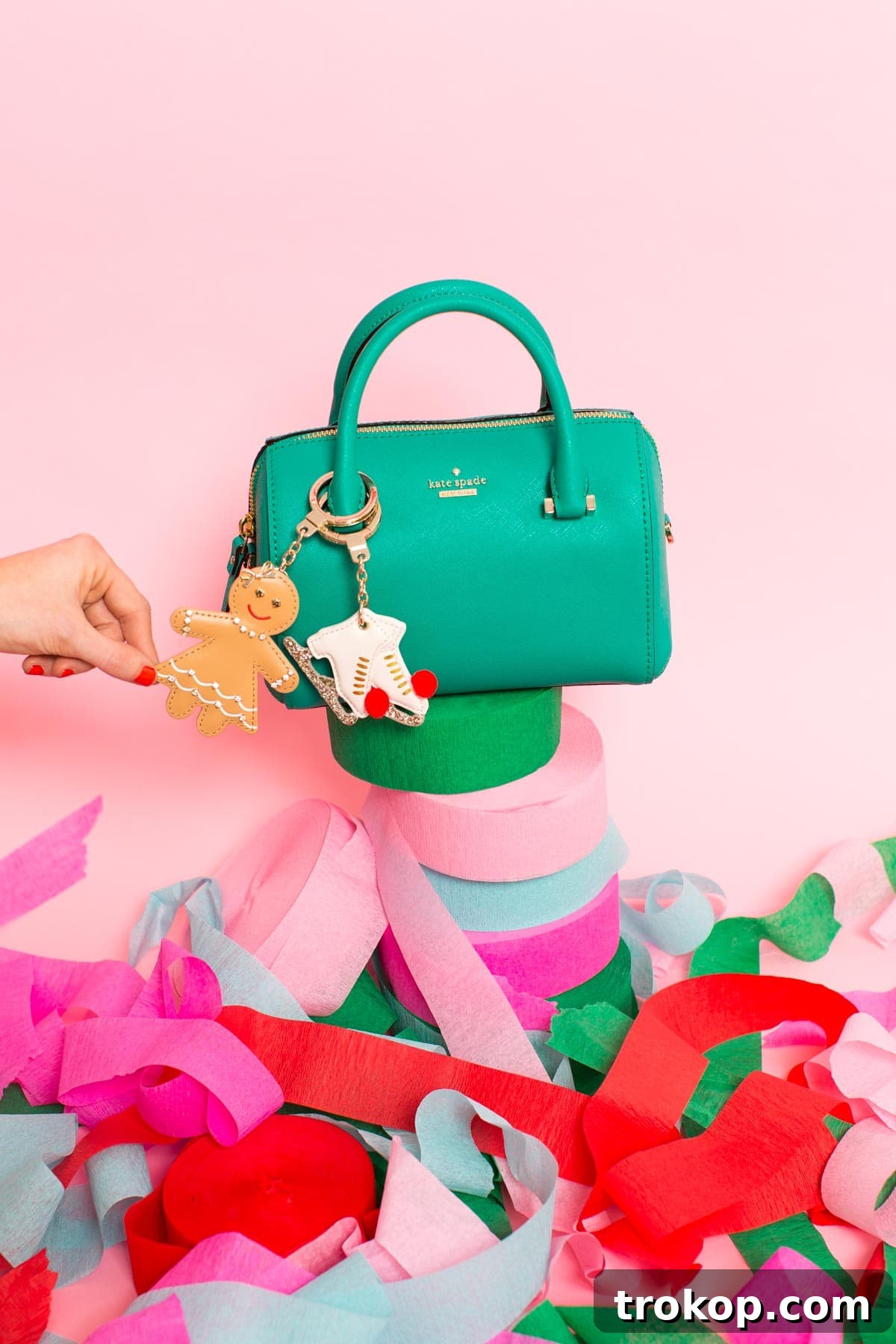 Close-up of a Kate Spade handbag with a variety of colorful charms attached, including an ice skate charm.