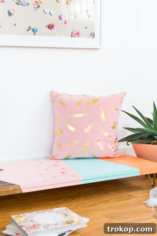 The finished DIY modern low bench, adorned with a throw pillow, showcasing its versatility and stylish design.