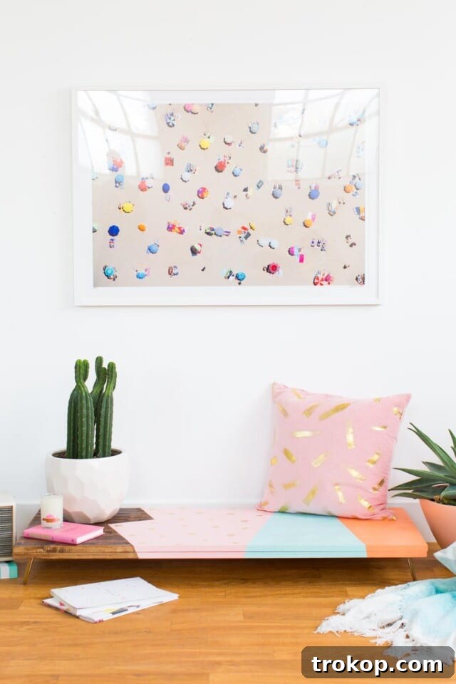A close-up view of the abstract design on a low DIY bench, highlighting the colorful painted sections and natural wood stain.