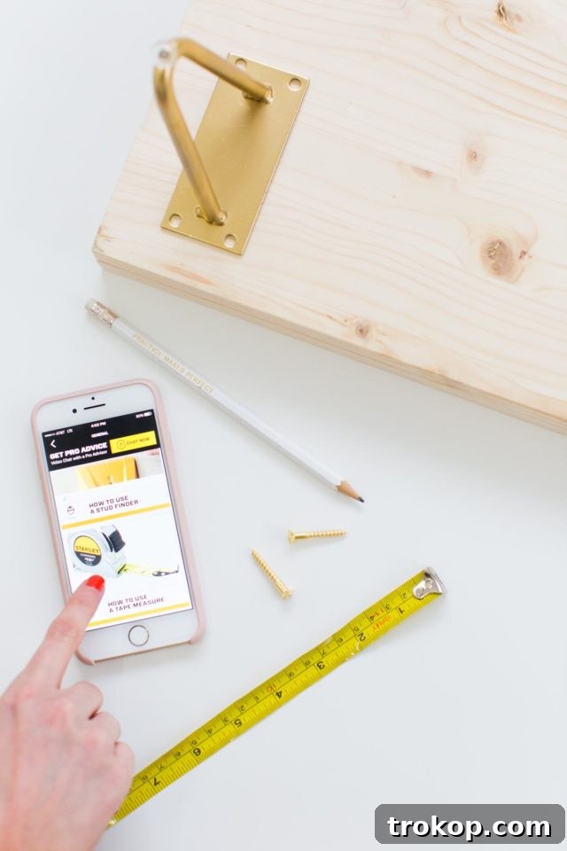 Measuring and marking the precise placement for the hairpin legs on the underside of the DIY modern low bench.