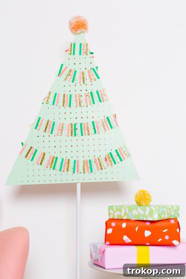 Craft a Modern Pegboard Christmas Tree 3 A brightly lit pegboard Christmas tree adorned with minimalist decorations, showcasing its modern design.