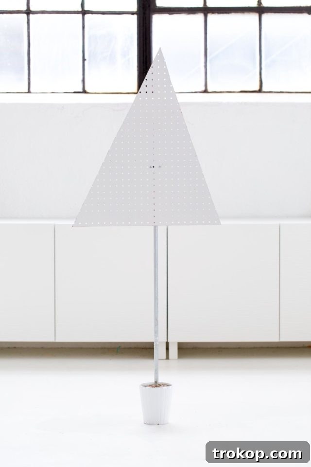Craft a Modern Pegboard Christmas Tree 6 Hands carefully inserting a metal pole into a ceramic planter filled with freshly mixed quick-setting cement, ensuring a sturdy base for the pegboard tree.