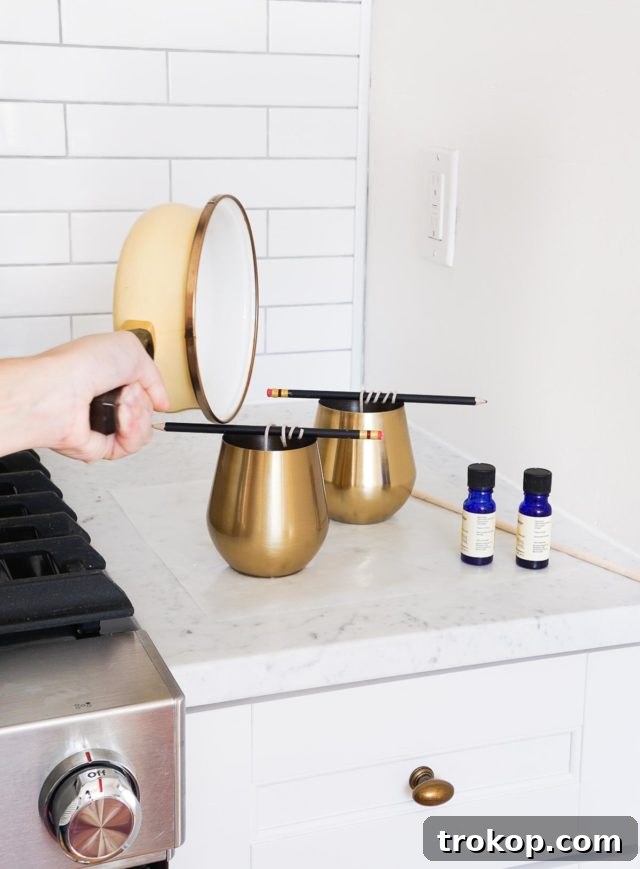 Pouring scented wax into a prepared candle container, leaving space at the top.
