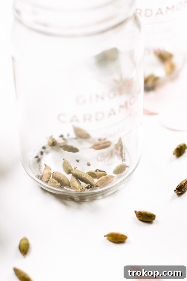 A collection of ginger infused gin bottles, beautifully decorated with custom labels, showcasing the perfect holiday cocktail gifts. A thoughtful and unique DIY present.