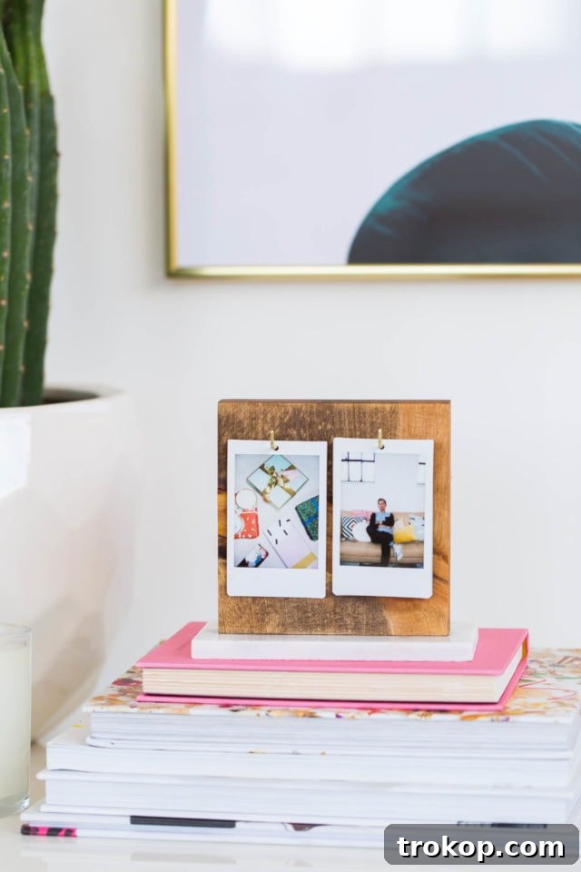 Craft Your Own Flip Photo Book 3 Detail shot of an open DIY Flip Photo Album, showcasing two Instax photos on a wooden stand with a marble base.