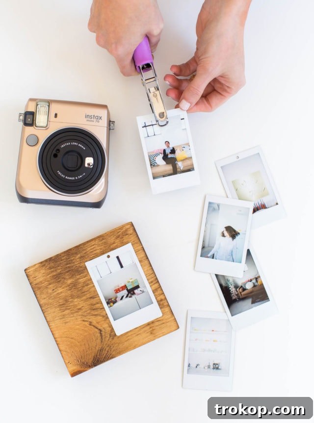 Craft Your Own Flip Photo Book 6 Instax prints being hole-punched and marked for hook placement on a wooden base.