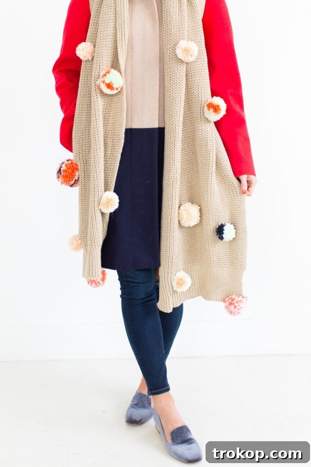 A selection of colorful yarn and craft tools for making a DIY Pom Pom Scarf.