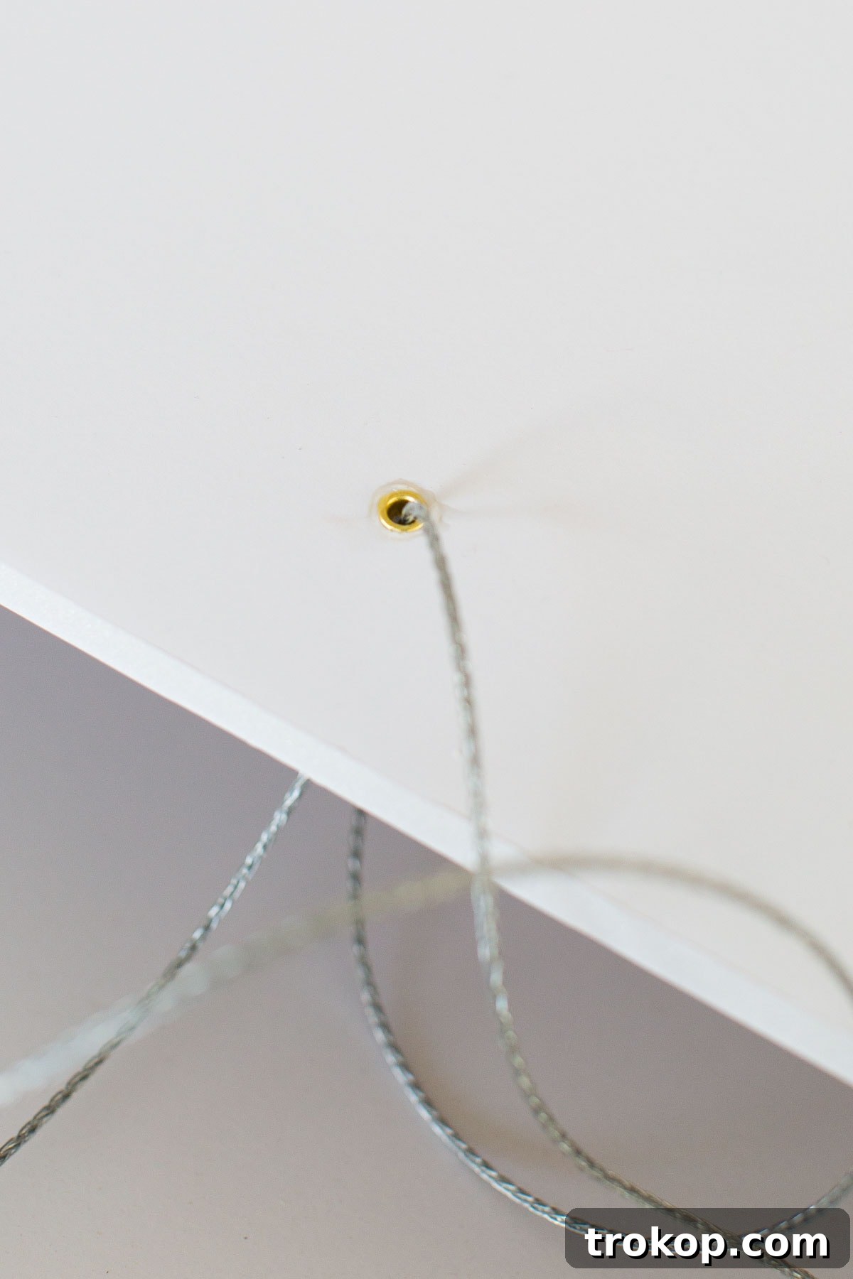 Step 2: Attaching eyelets to foam board for secure hanging