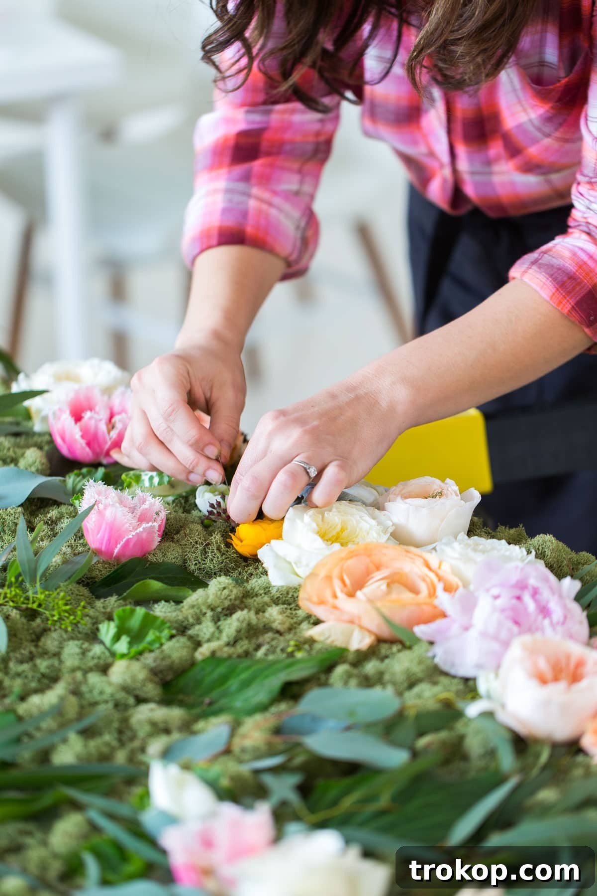 Step 4: Pinning flowers onto the moss-covered board in a beautiful arrangement