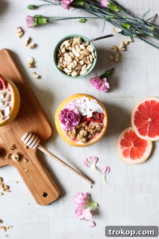 Close-up of a refreshing Winter Citrus Smoothie served in a halved grapefruit, garnished with tropical flair. A signature recipe from Sugar & Cloth's DIY collection.