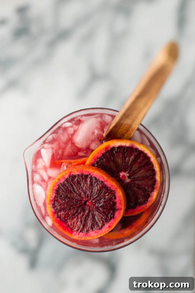 Vibrant Blood Orange Sangria 3 Close-up of Blood Orange Sangria in a glass pitcher, highlighting the vibrant slices of blood orange and the rich color of the drink.