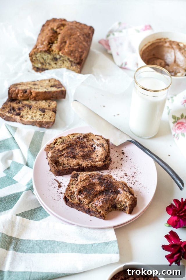 A beautiful loaf of chocolate chip banana bread sliced and ready to serve with mocha mascarpone.