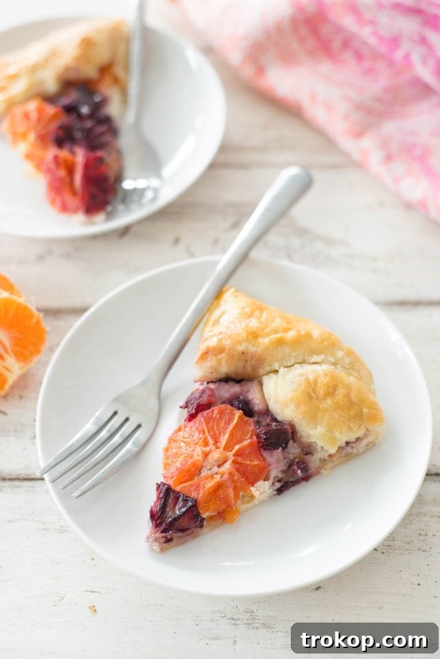 A stunning Citrus Galette by Sugar & Cloth, featuring vibrant orange slices on a flaky crust with ricotta.