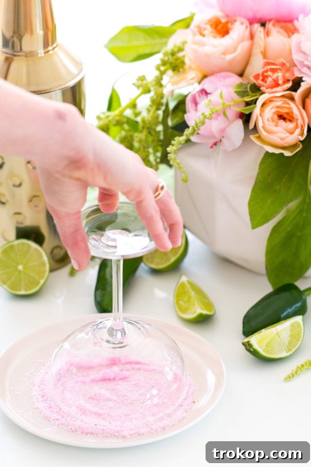 A vibrant jalapeño margarita in a glass with a salt rim