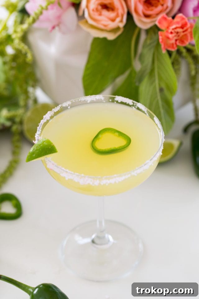 A refreshing skinny margarita with a jalapeño slice and lime wedge