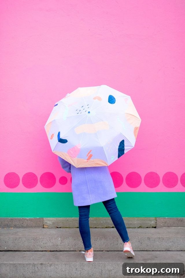 Fashionable person holding a DIY abstract painted umbrella, adding a pop of color to their outfit