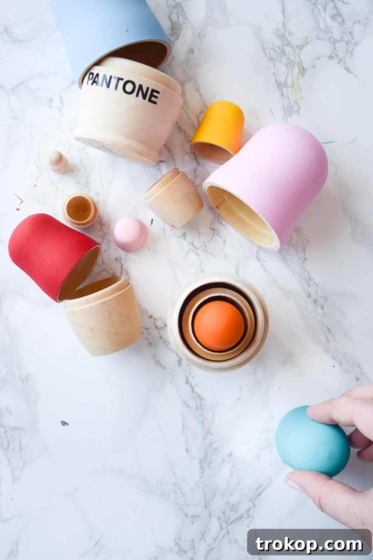 DIY Pantone Nesting Dolls: A step-by-step guide to transforming wooden nesting dolls into colorful, modern decor inspired by Pantone color swatches.