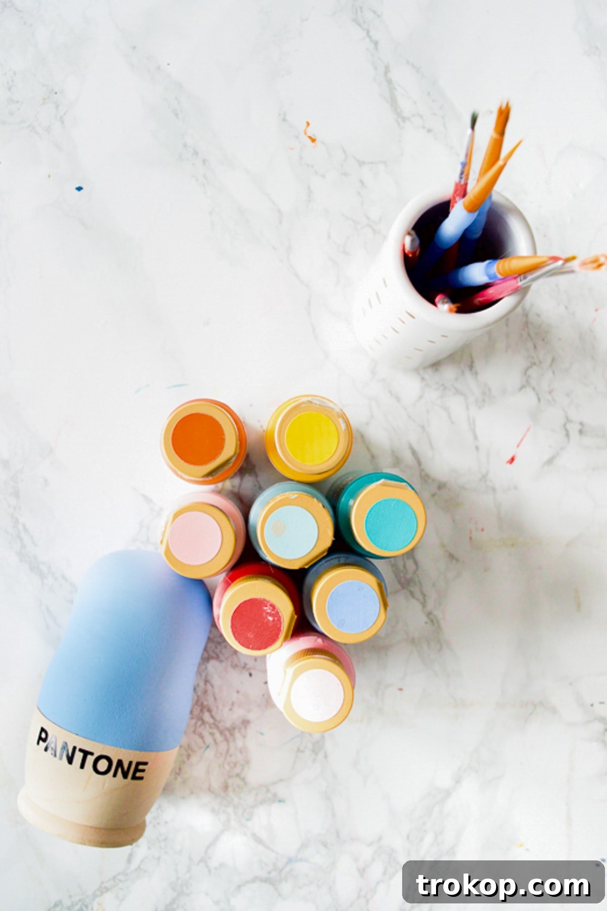 A vibrant selection of acrylic paints, carefully chosen for their modern aesthetic, ready to transform wooden nesting dolls into a stunning color palette display.