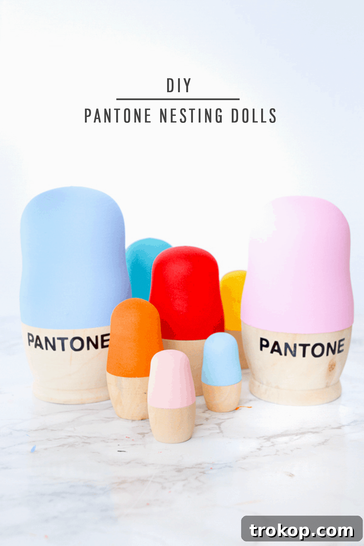 A beautifully arranged collection of DIY Pantone nesting dolls, featuring various sizes and a harmonious color scheme, perfect for modern home decor or as a unique gift idea.
