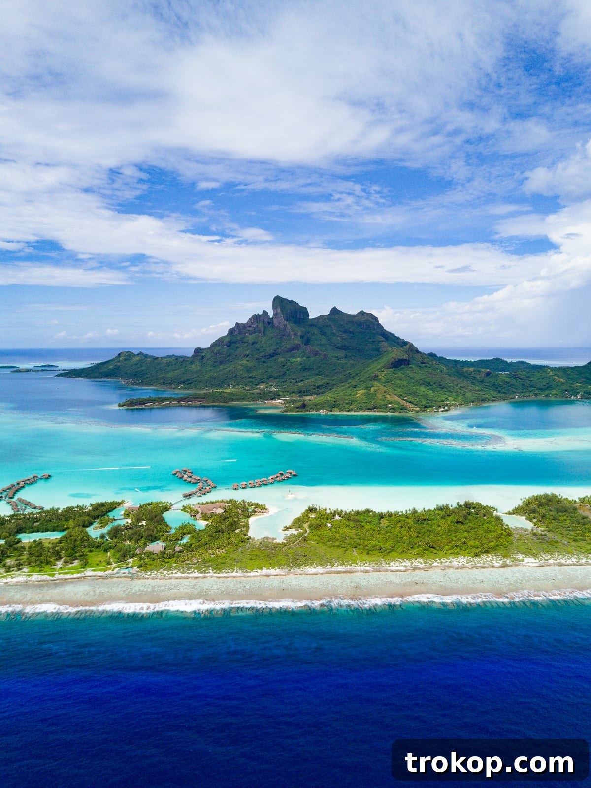 View of multiple overwater bungalows stretching into the lagoon