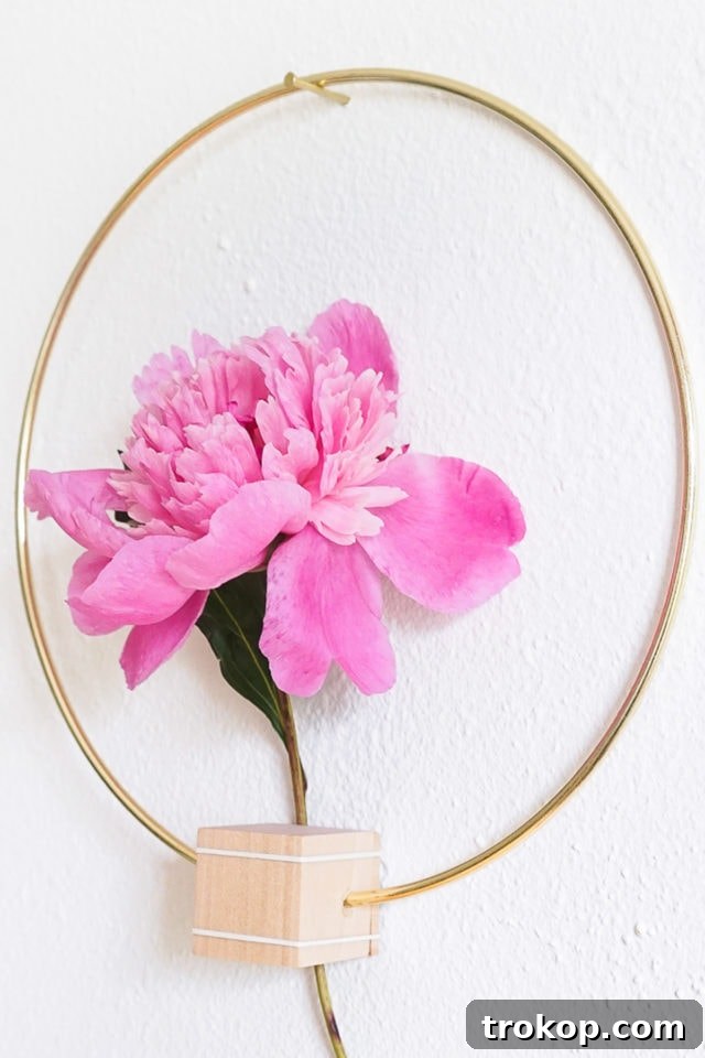 Close-up of a DIY Minimalist Flower Wall Hang with a fresh pink flower, illustrating easy crafting