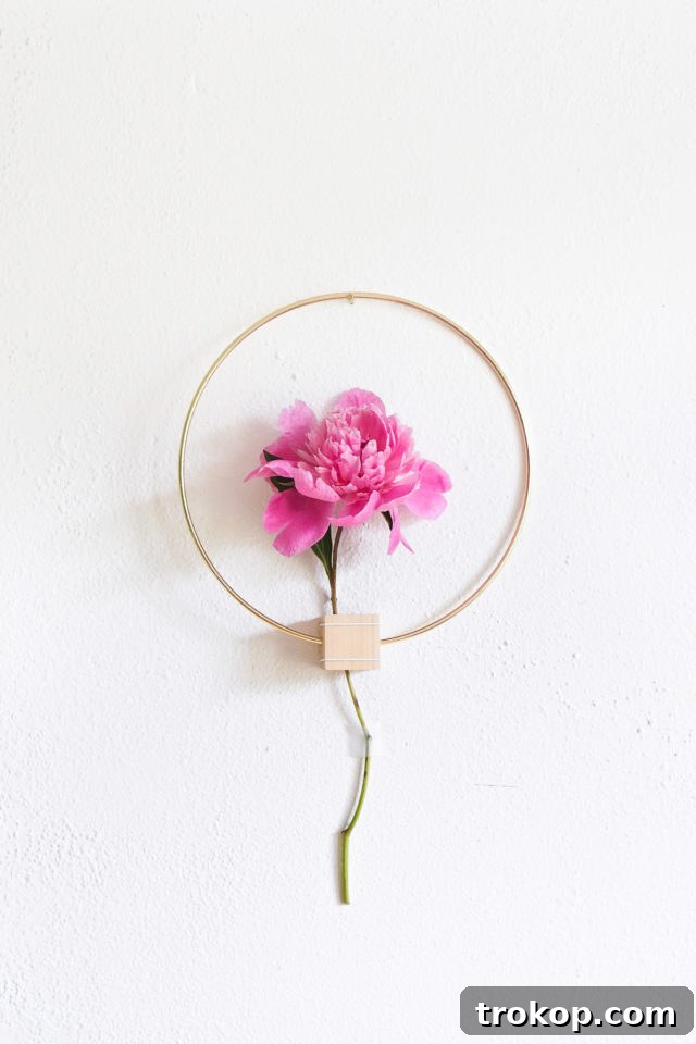 Selection of materials for a DIY Minimalist Flower Wall Hang, including gold hoop, wood cube, and fresh flowers