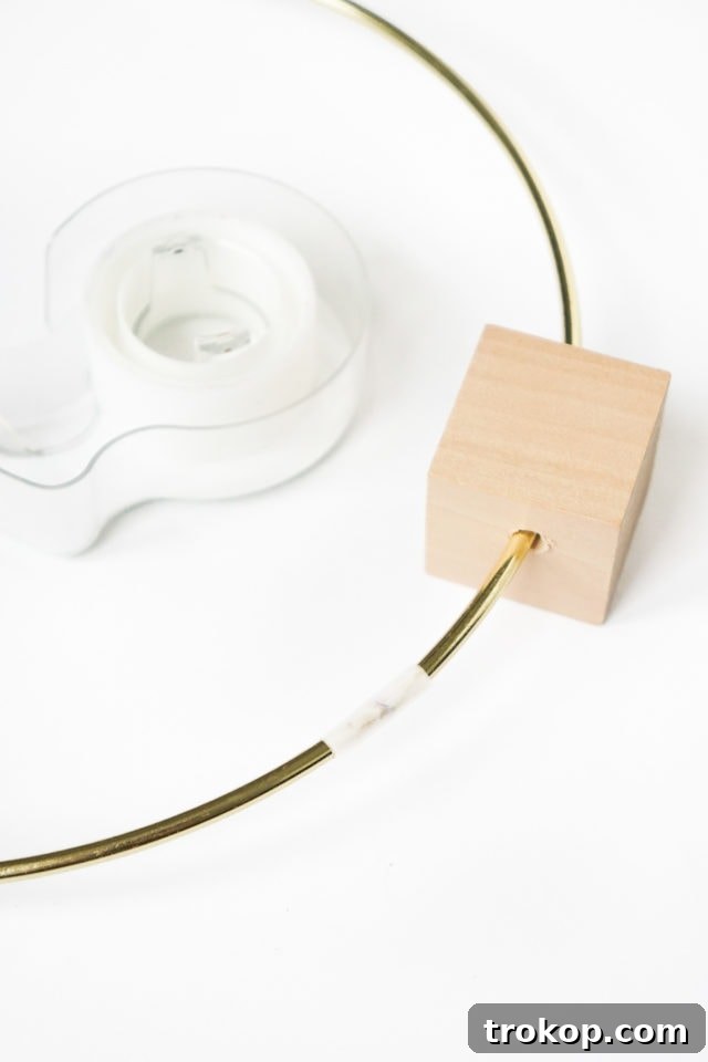 DIY Minimalist Flower Wall Hang: Step 3, sliding the cube onto the hoop and securing with tape