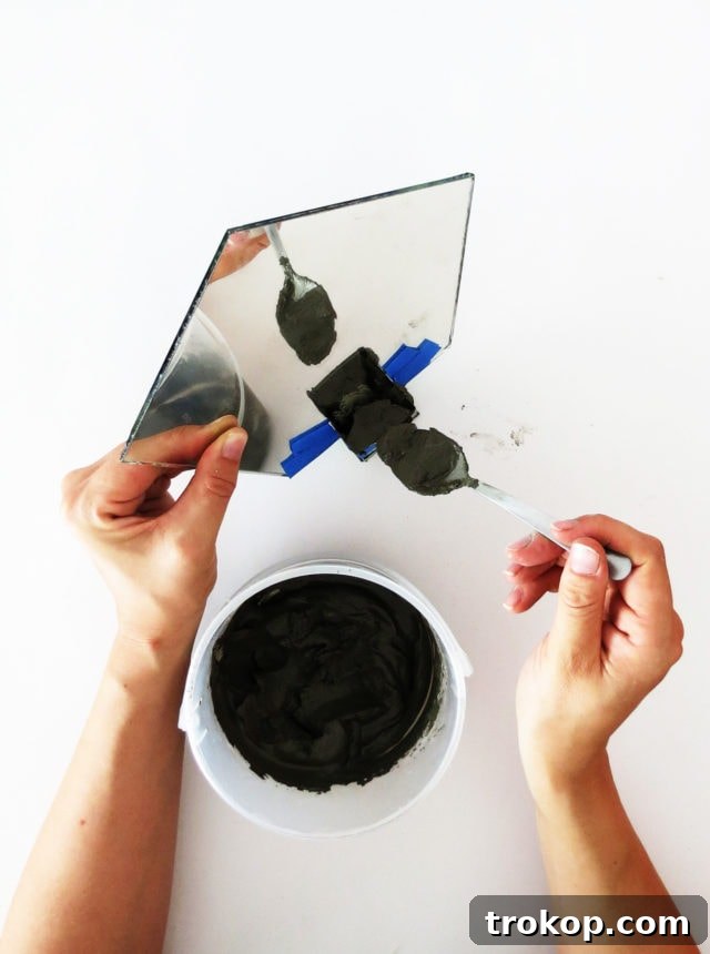 Pouring concrete into the mirror mold, ensuring stability.