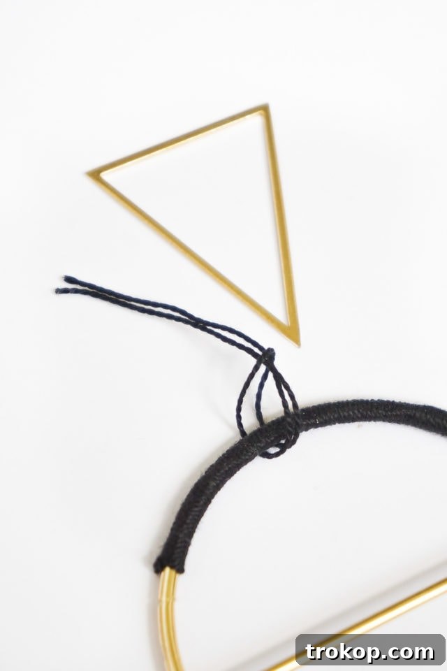 Step 7: Attaching the inverted gold triangle to the top of the main hoop