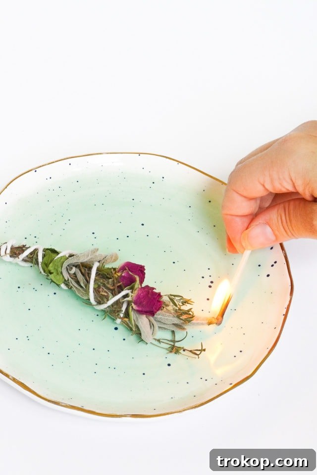 Three freshly made floral and sage incense bundles on a light background, showcasing vibrant flowers and green sage leaves. Perfect for DIY herbal incense projects and home decor.