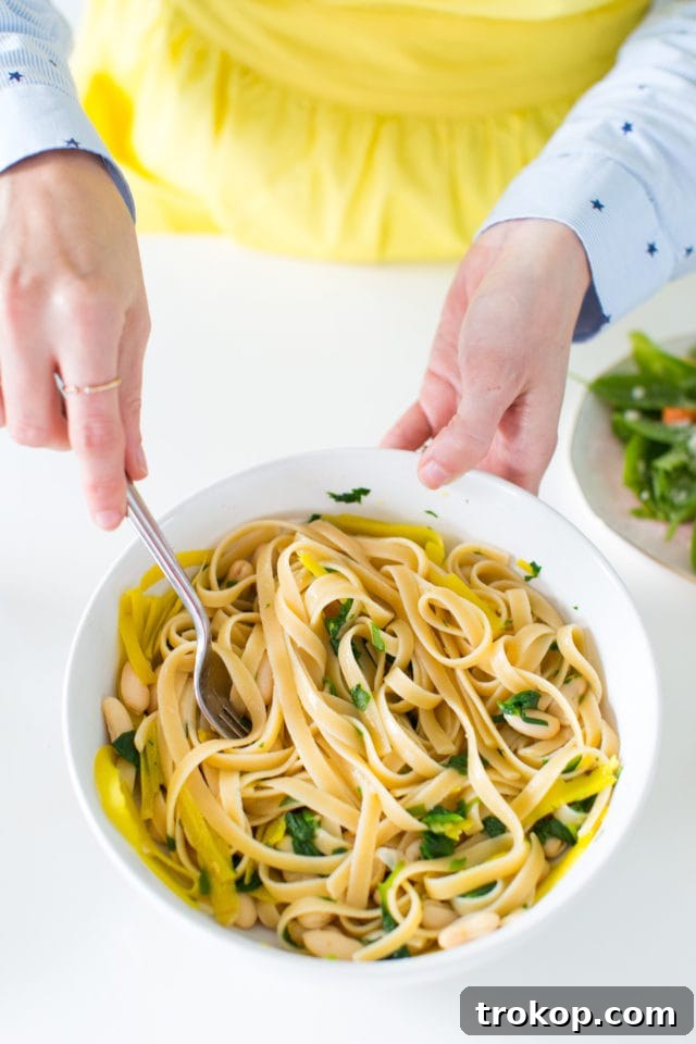 Close-up view of the perfectly coated fettuccine pasta with creamy Roasted Garlic White Bean Alfredo sauce.