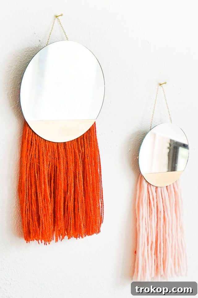 DIY Fringed Mirror Wall Hanging featuring a round mirror, yarn fringe, and gold painted accents, perfect for boho decor.